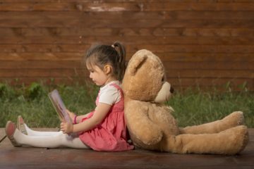 niña-leyendo-de-espaldas-a-un-oso-de-peluche
